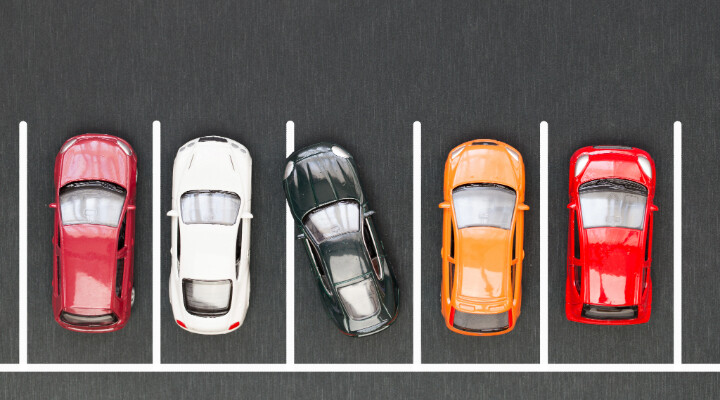 Parking lot with cars parked, representing secure parking options for cars, SUVs, and pickup trucks.